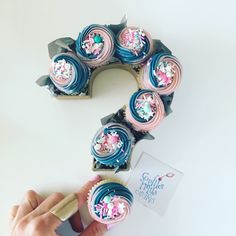 someone is decorating cupcakes with blue icing and sprinkles