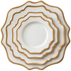 four white and gold plates stacked on top of each other, with one plate in the middle