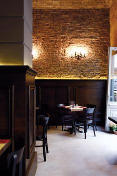 an empty restaurant with brick walls and tables