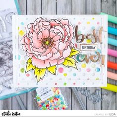 a birthday card with flowers and confetti on the table next to some markers