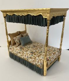 a miniature bed made to look like it is in the shape of a four poster bed