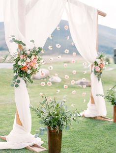 an outdoor ceremony setup with flowers and greenery