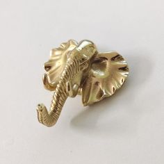 an elephant shaped brooch sitting on top of a white table