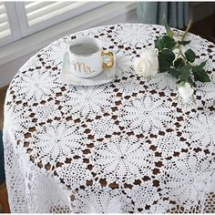 a table with a white doily on it and a coffee cup next to it