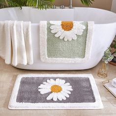 two bath mats sitting next to each other on a bathroom floor near a white tub