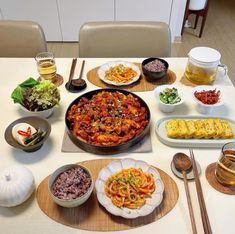 a table topped with plates and bowls filled with different types of food next to utensils