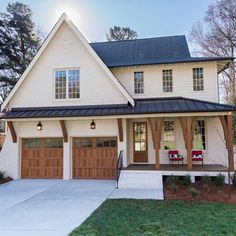 a white house with two garages in the front and one on the other side