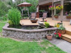 an outdoor patio with a pond and seating area for people to sit on the deck