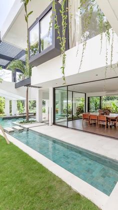 an outdoor dining area and pool in the middle of a house with large sliding glass doors