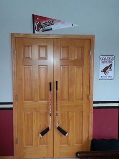 two wooden doors with hockey sticks sticking out of them