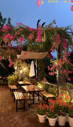 an outdoor dining area with benches and flowers