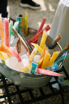 a metal bowl filled with lots of different colored sticks