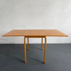 a wooden table sitting on top of a gray floor