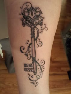 a tattoo on the leg of a woman with a key