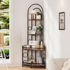 a living room with white walls and wooden flooring, a book shelf filled with books