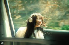 a woman with headphones sitting in a car