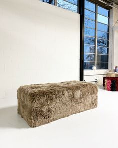 a large furry bench sitting in front of a window