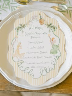 a white plate topped with a menu on top of a wooden table next to silverware