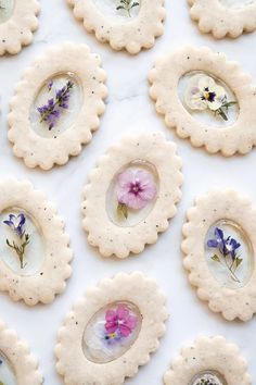 cookies decorated with pressed flowers are arranged on a table