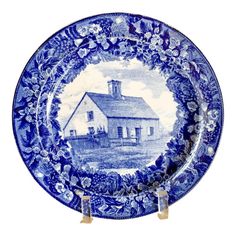 a blue and white plate with an image of a house in the middle of it