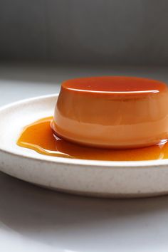 an orange sauce is sitting on a white plate