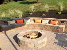 an outdoor fire pit with seating around it