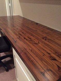 an office desk made out of wood and white drawers