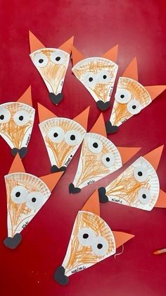 paper plate fox craft on red background with orange and black accents, including one cut out to look like it has eyes