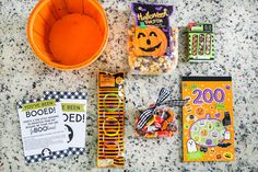 the contents of a halloween treat bag laid out on a table with candy and candies