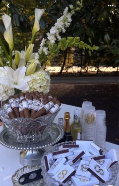 a glass bowl filled with lots of chocolates and flowers on top of a table