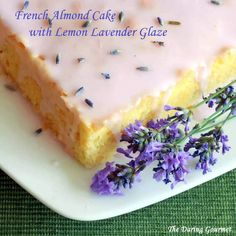 a piece of cake sitting on top of a white plate with lavender sprinkles