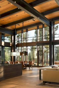 a living room filled with furniture and lots of glass windows on the wall next to each other