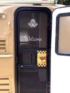 an open door to a vehicle with a welcome sign on the side and a chandelier hanging from it