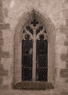 an old church window with iron bars on it