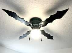 a ceiling fan with two bats painted on it's blades and the light shining through