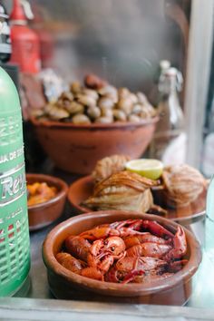 there are many different types of food on the counter top, including shrimp and mussels