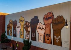 a large mural on the side of a building with many different hands painted on it