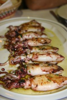 an octopus dish is served on a white plate