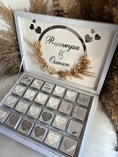 a box filled with lots of silver hearts on top of a white table next to fur