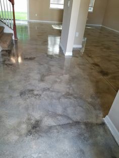 an empty room with concrete flooring and stairs leading to the second story window in the house