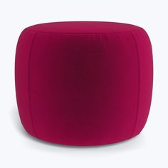 a red ottoman sitting on top of a white floor