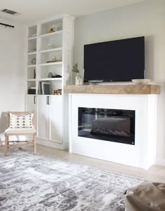 a living room with a fireplace, television and bookshelves