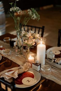 the table is set with candles and plates