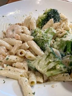 a white plate topped with pasta and broccoli