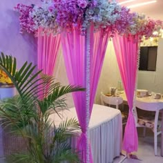 a bed with pink drapes and flowers on it