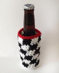 a black and white bottle holder with a red cap on the top is holding a beer