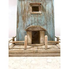 an old wooden dollhouse with a cat in the window