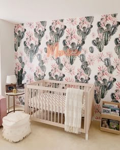 a baby's room with cactus wallpaper and crib in the foreground