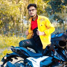 a man sitting on top of a blue motorcycle