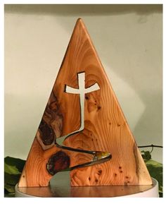 a wooden triangle with a cross on it and other items in front of the triangle